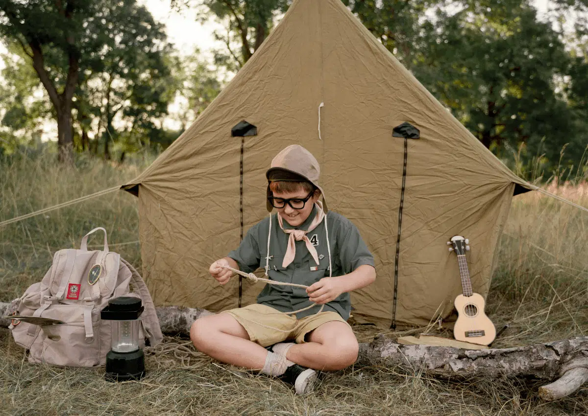 adolescente acampando e fazendo nós