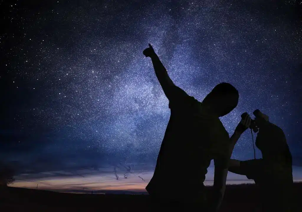 duas pessoas admirando o céu estrelado